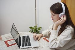 Side view of student studying online at home