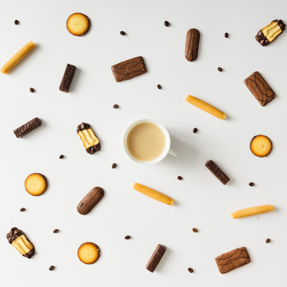 Coffee cup with cookies and coffee bean pattern on light background