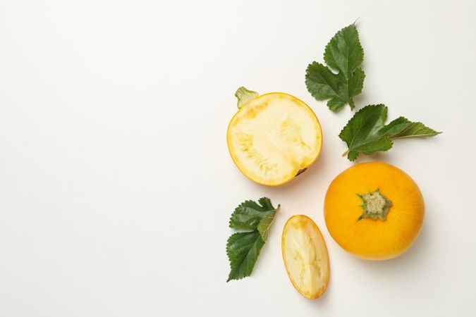 Round zucchini and leaves on neutral background