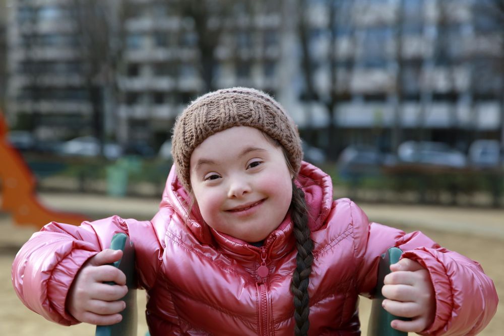 Happy child climbing up slide on playground