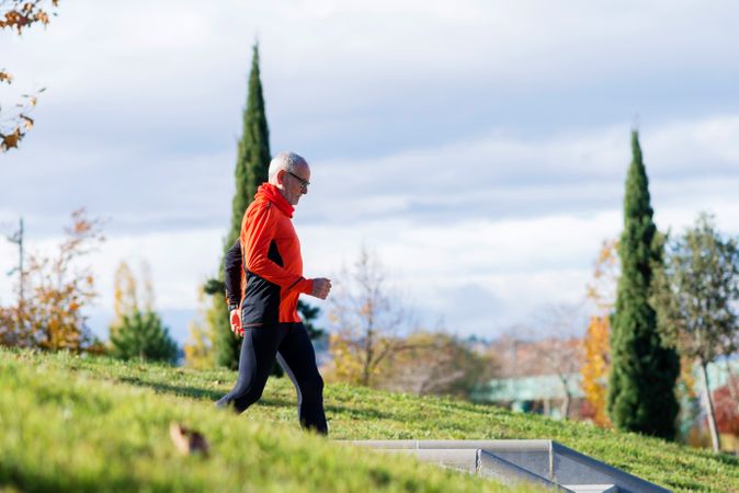 Older male walking through park on fall day