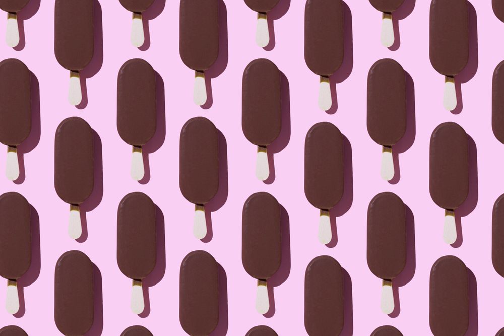 Chocolate popsicle in neat order on pink background