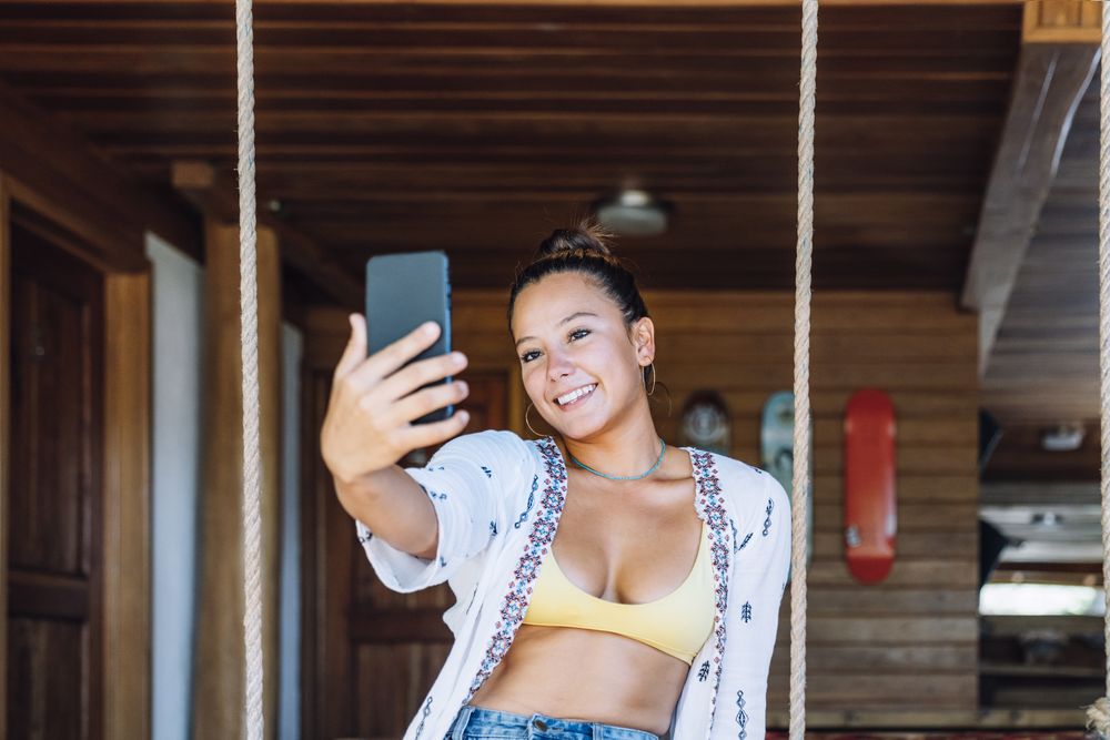 Cheerful woman taking selfie at home