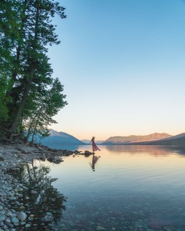 Woman standing on rock near body of water