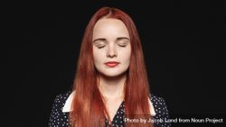Portrait of a woman with long reddish brown hair isolated on dark background 0JAOpb