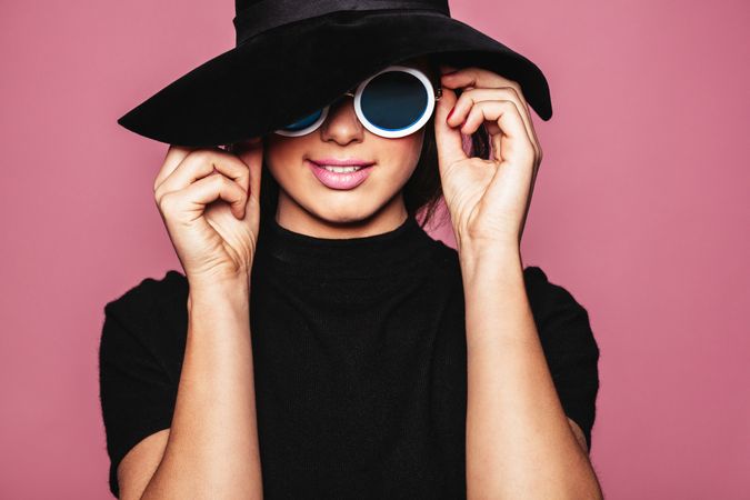 Female model wearing hat and stylish sunglasses