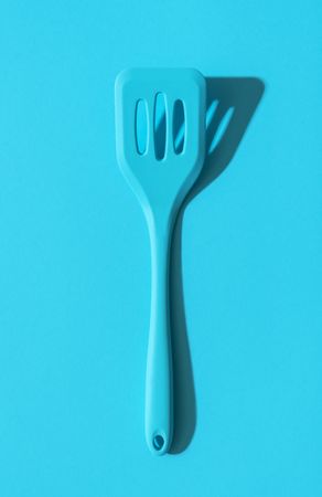 Blue spatula above view on a blue background