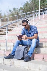 Male sitting on outdoors steps and reading