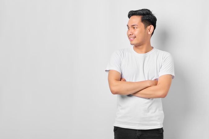 Asian male in grey studio looking away with copy space