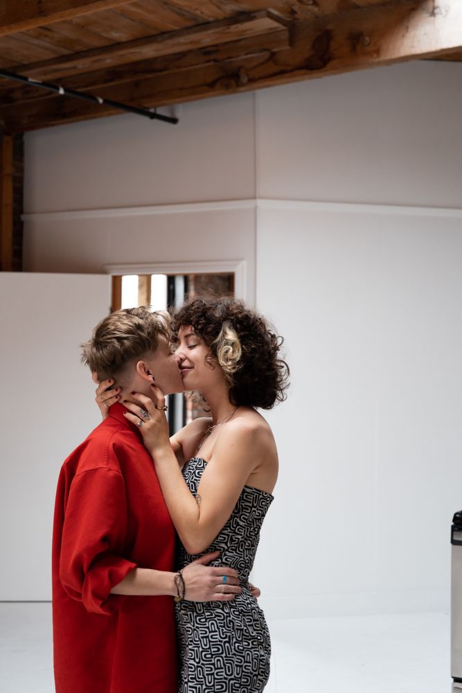 Two young partner women kiss