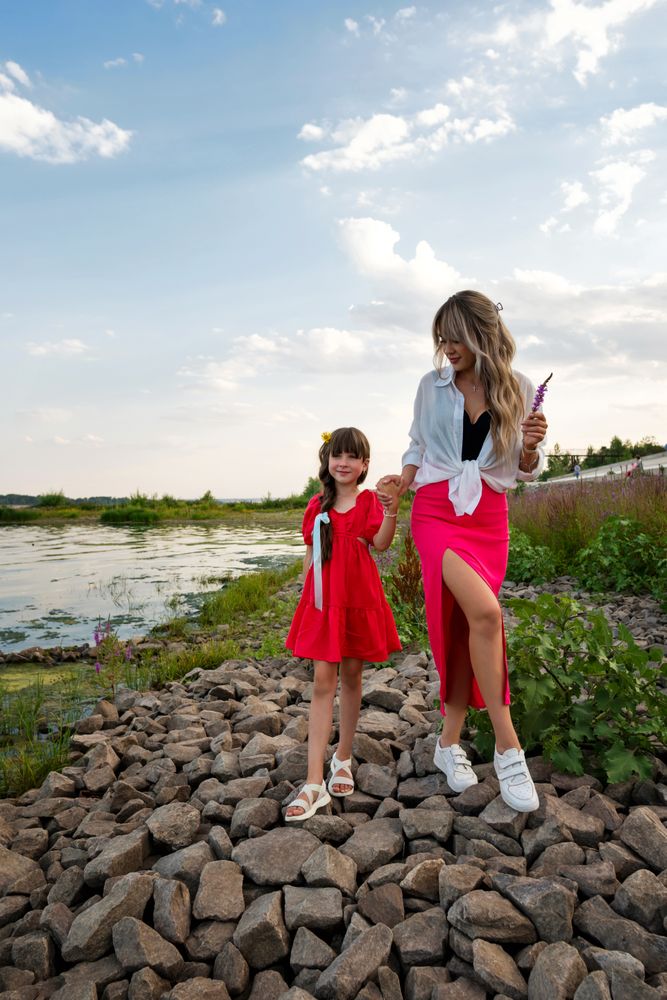 Mom and little daughter walking by the lake or pond