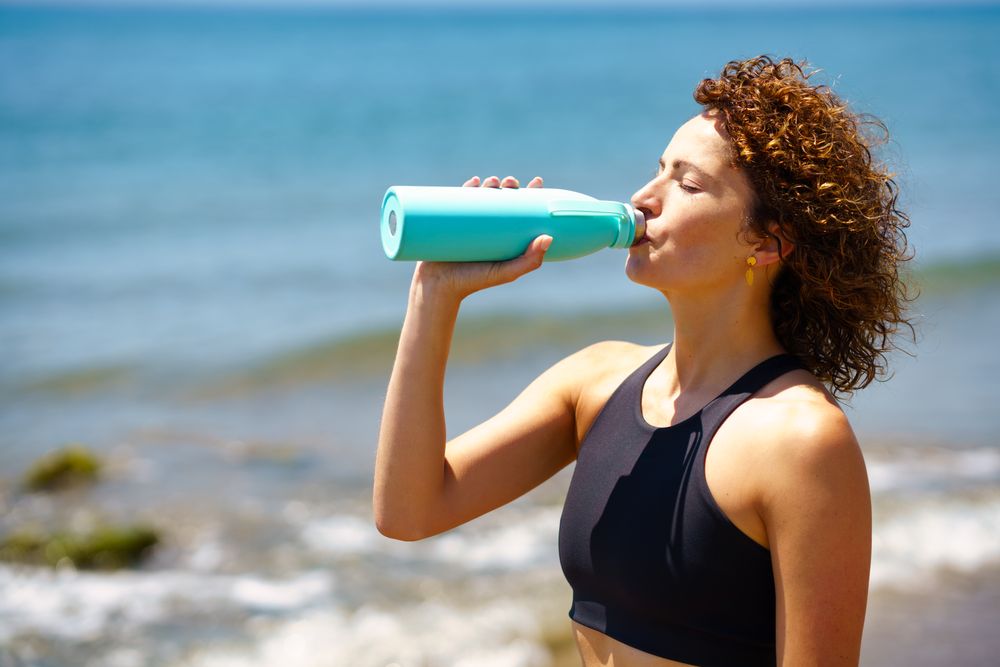 Sportswoman drinking water from bottle