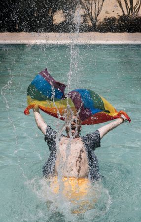 Excited gay man in swimming pool