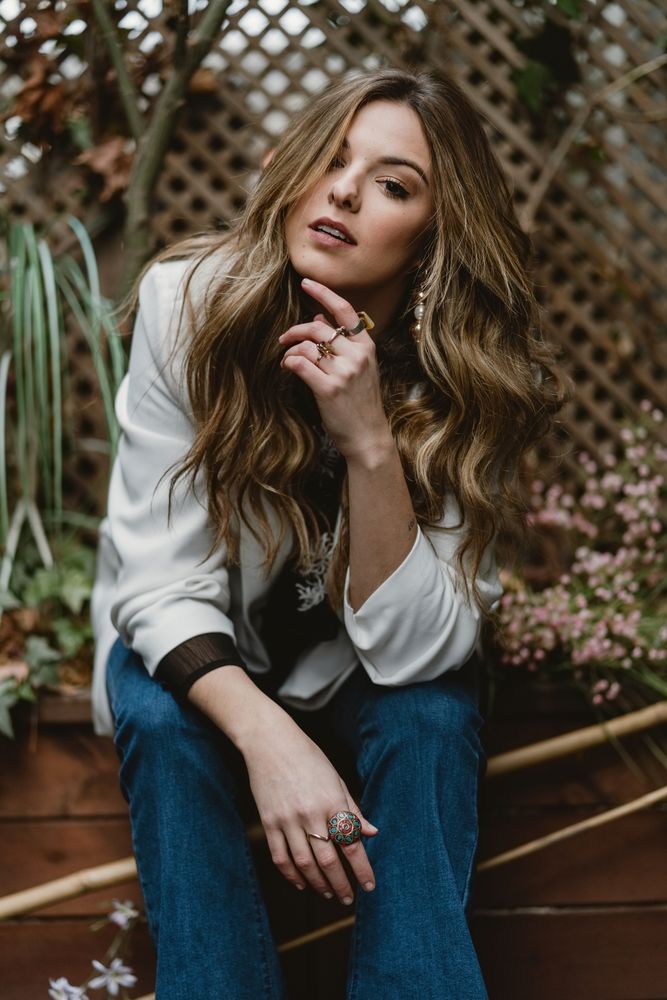 Woman sitting on planter in garden