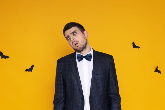 Concept of Halloween, young man on yellow background