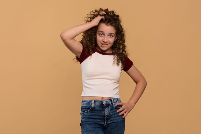 Young girl scratching head and biting lip, showing confusion