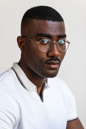 Serious Black man in eyeglasses on white background