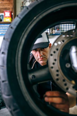 Mechanic fixing custom motorcycle wheel