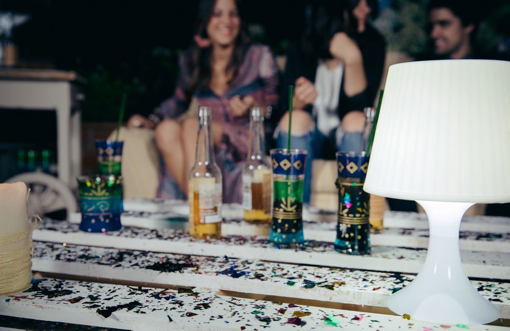 Lamp over pallets table with confetti in outdoors party