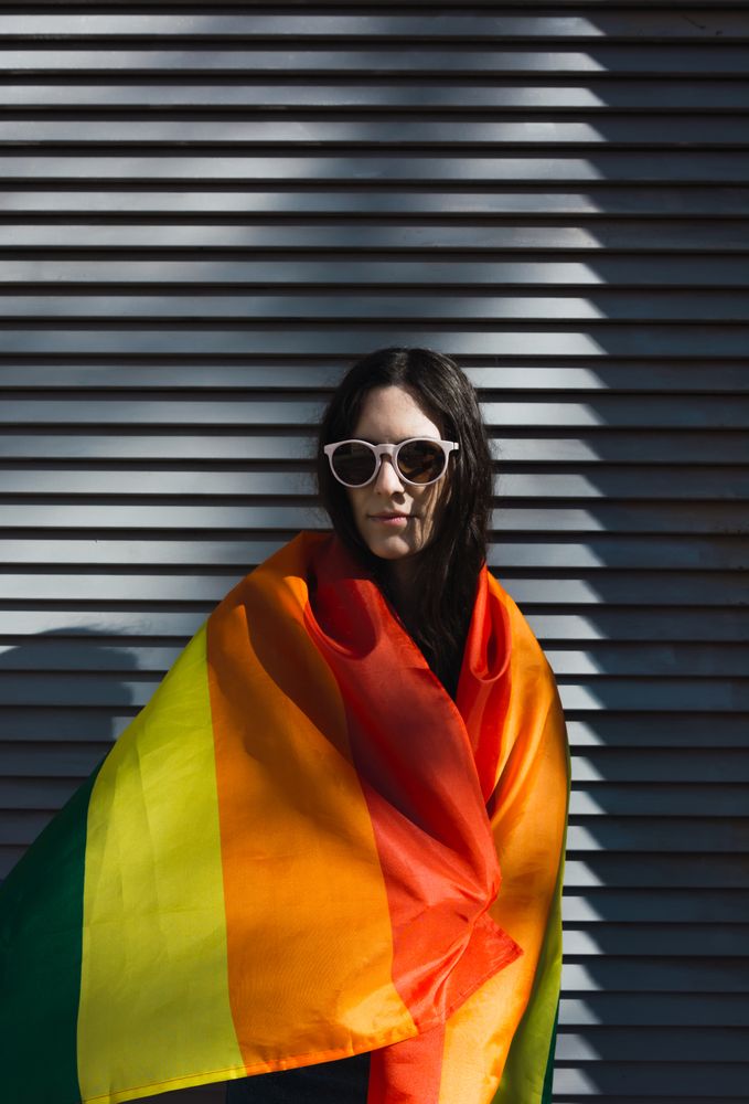 Woman posing happily with the LGBTQIA flag
