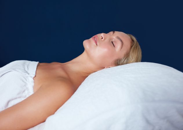 Blonde woman lying back during beauty with eyes closed