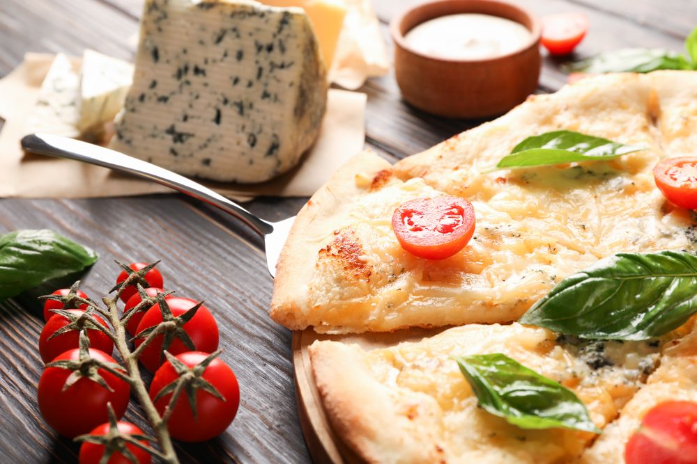 Cheese pizza and ingredients on wooden background, closeup