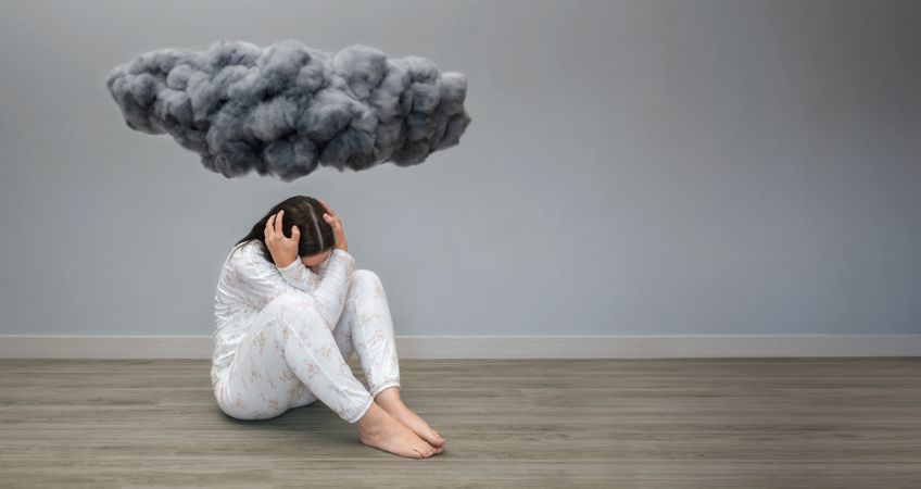 Unrecognizable woman under a dark storm cloud