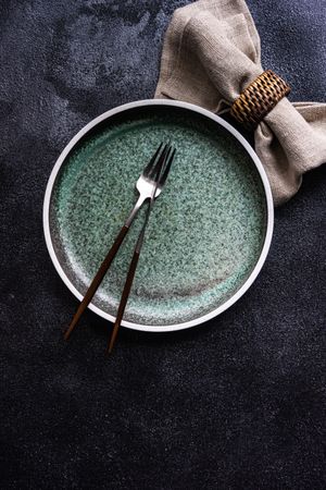 Empty grey plate with silverware as a table setting concept