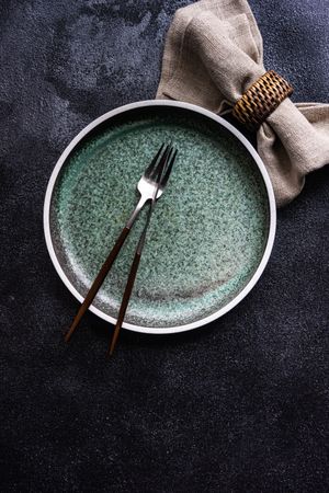 Empty grey plate with silverware as a table setting concept