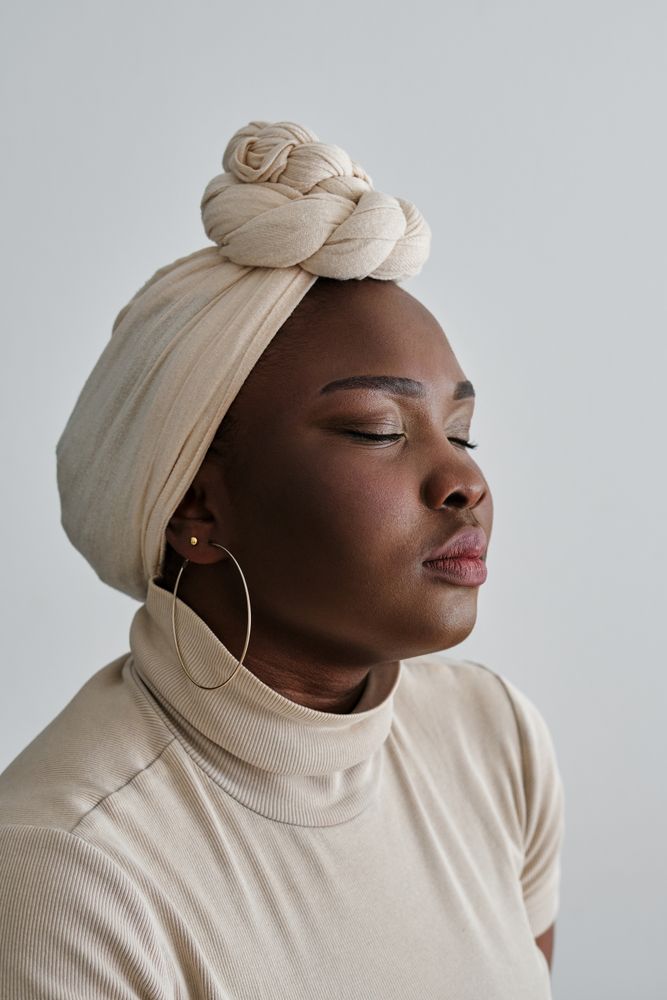 Charming Black lady in headscarf with closed eyes