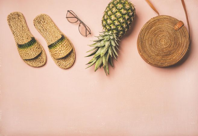Sandals, glasses, pineapple, bag on pink background, with copy space