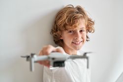 Cheerful boy holding toy drone