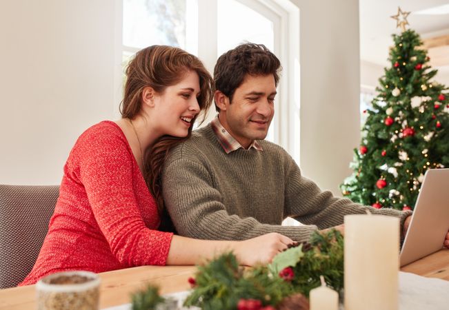 Young couple at home shopping online for christmas