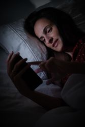 woman browsing smartphone at night time