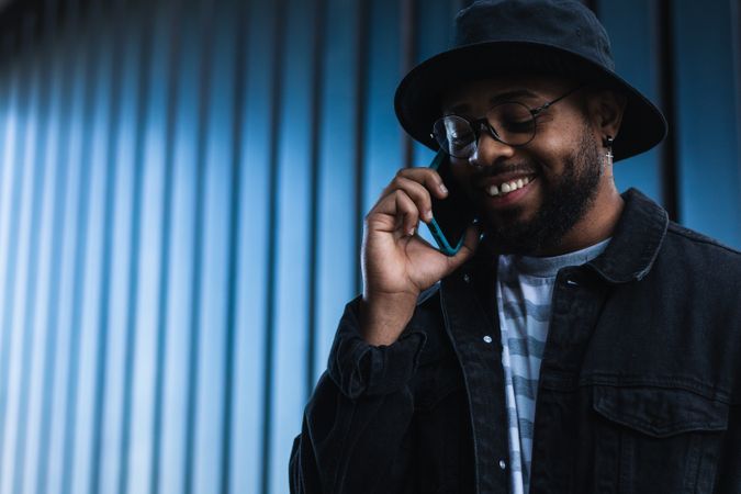 Laughing Black man talking smartphone
