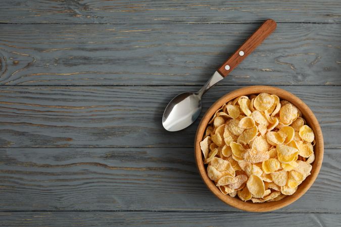 Spoon and bowl of muesli on wooden background