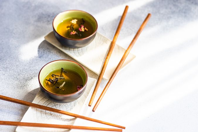 Tea time concept with two cups of green tea and chopsticks