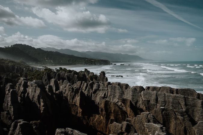 Blue waves washing rocky seashore in bright day