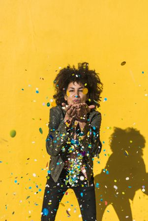 Black woman with afro hair celebrating with confetti.