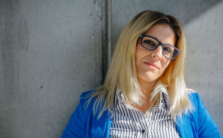 Businesswoman posing on concrete wall