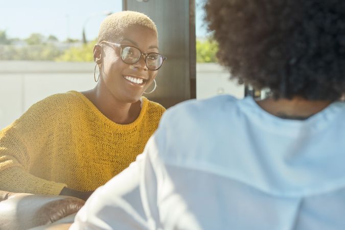 Smiling Black woman looking at friend in restaurant