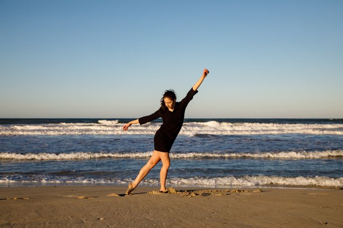Woman with dancing near water on shore
