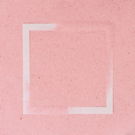 Pink sand covering parts of paper square outline