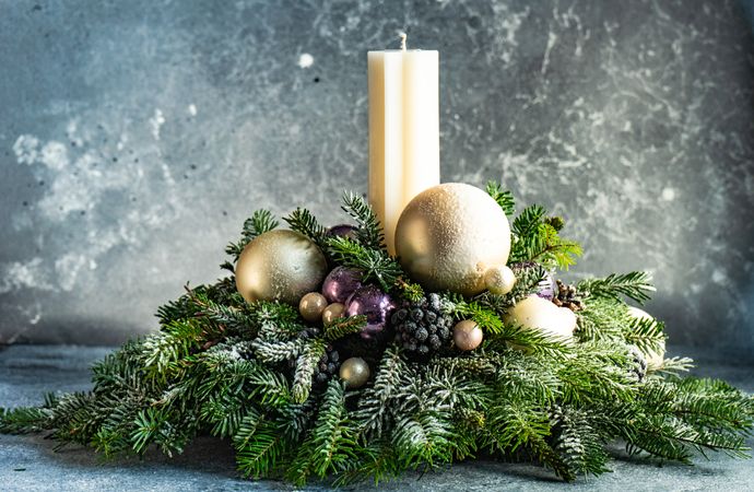 Side view of purple and gold Christmas decorations in pine branch on table