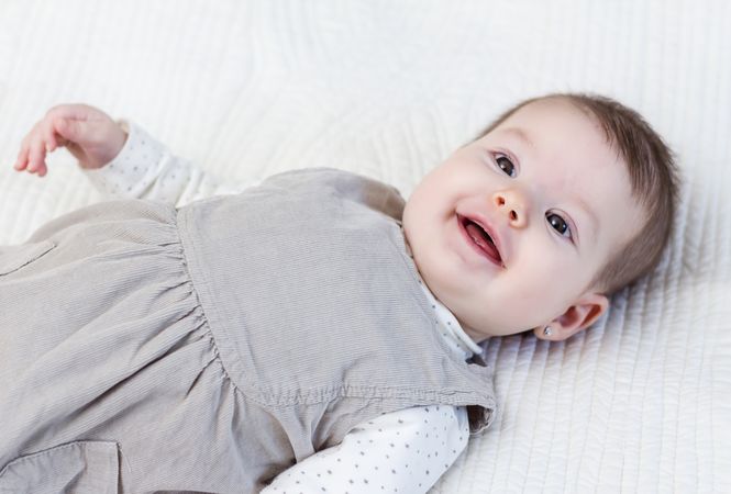 Happy baby girl lying on back