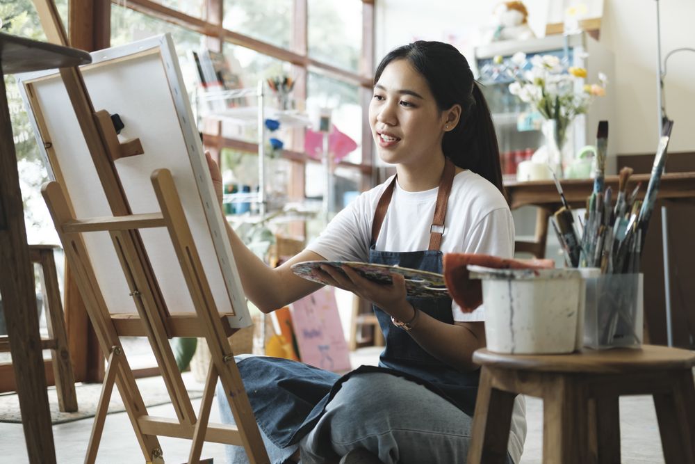 Crafting Inspiration. Female Artist Sketching and Painting in Workshop