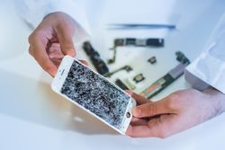 Crop hands showing broken smartphone display