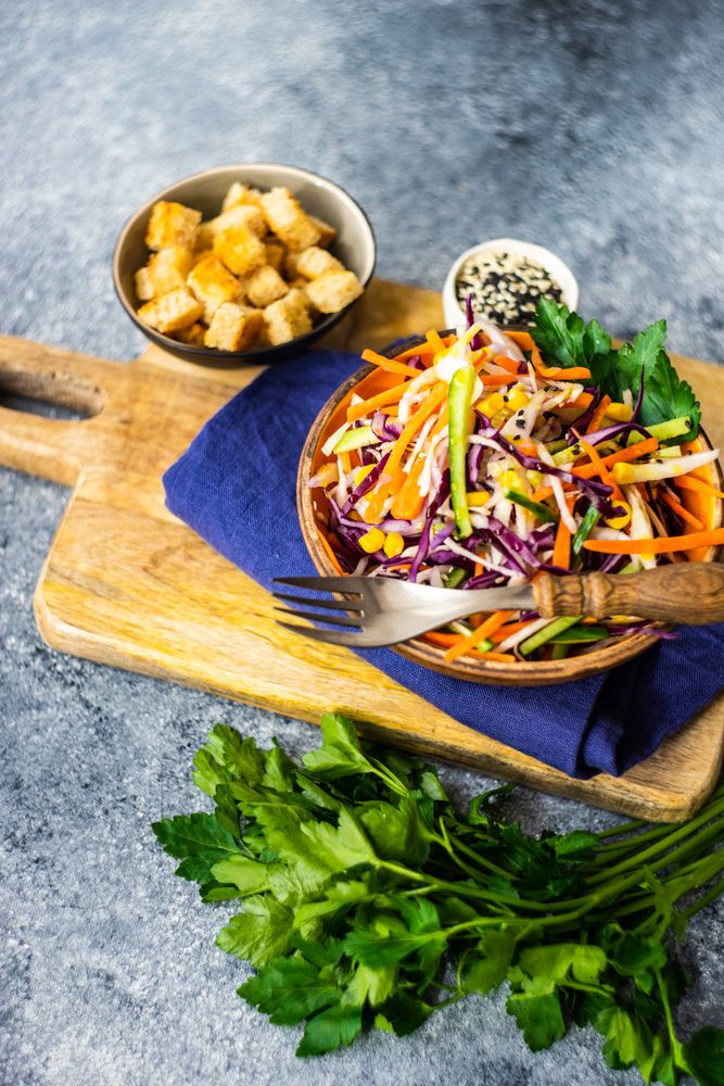 Fresh salad with vegetables in bowl on stone background with copy space