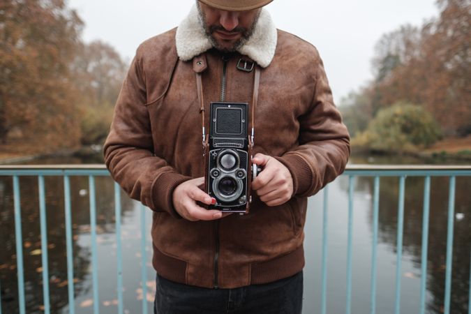 Male tourist with vintage camera near river