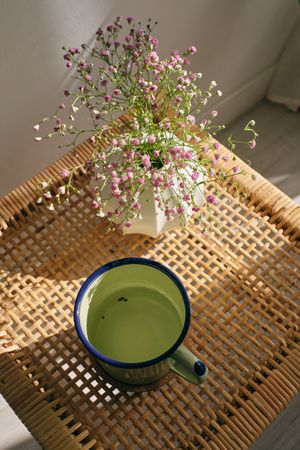 Cup of tea and blooming gypsophila on wicker table